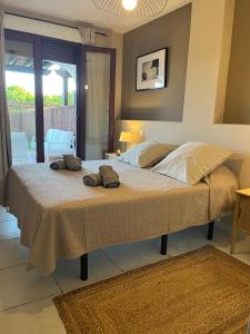 1 dormitorio con 1 cama grande y toallas. en Jardines de Nuevo Vera - Magnífico Apartamento a Pie de Playa, en Vera