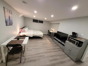 um quarto de hotel com uma cama, uma mesa e cadeiras em Guest House Basement - Master Bedrooms in Bayview Village em Toronto