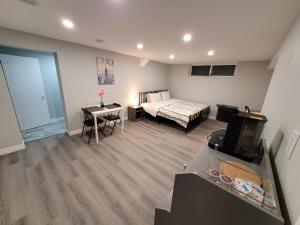 a bedroom with a bed and a desk with a television at Guest House Basement - Master Bedrooms in Bayview Village in Toronto
