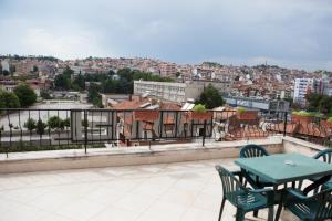 einen Tisch und Stühle auf einem Balkon mit Stadtblick in der Unterkunft Hotel Deva in Sandanski