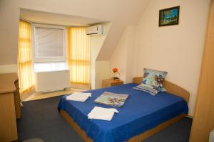 ein Schlafzimmer mit einem blauen Bett und Handtüchern darauf in der Unterkunft Hotel Deva in Sandanski