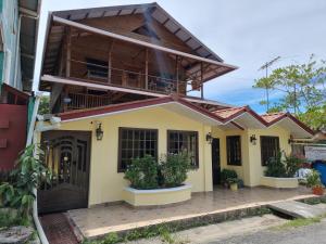 a house with a balcony on top of it at Hostal Bocas Tropical Paradise in Bocas Town