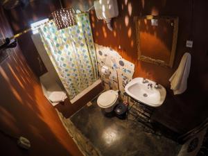 uma casa de banho com um lavatório, um WC e um espelho. em Casamolle Hostel em Tilcara