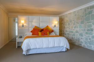 um quarto com uma cama com almofadas vermelhas e laranja em Casa Hidalgo Hotel Boutique em Oaxaca de Juárez