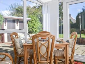 een afgeschermde veranda met een tafel en stoelen bij Highpool House in The Mumbles