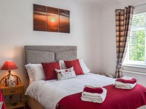 een slaapkamer met een bed met rode en witte kussens bij Highpool House in The Mumbles
