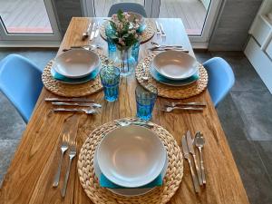 una mesa de madera con platos y cubiertos en Prime Loft ANDORRA, en Pas de la Casa