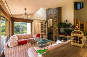 a living room with a couch and a bird cage at Villa vacacional Coto Blanco in Nueva de Llanes