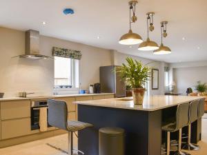 uma cozinha com uma grande ilha com cadeiras e uma mesa em Homewood - Uk36205 em Fordingbridge