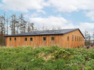 um celeiro de madeira com um telhado preto num campo em Homewood - Uk36205 em Fordingbridge