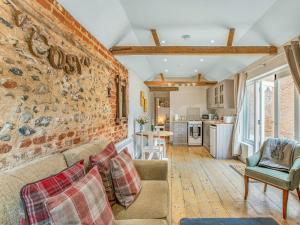 a living room with a couch and a brick wall at Barwick Lodge in Bawdeswell