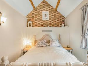 Cama en habitación con pared de ladrillo en Barwick Lodge en Bawdeswell