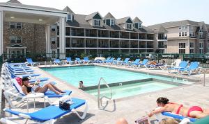 eine Gruppe von Personen, die am Pool auf Stühlen liegen in der Unterkunft Crown Choice Inn & Suites Lakeview and Waterpark in Mackinaw City