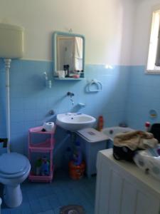 La salle de bains bleue est pourvue d'un lavabo et de toilettes. dans l'établissement Kuća sa apartmanom, à Sarajevo