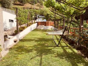 a yard with a hammock in the grass at Lagoon Tiny House in Arcos de Valdevez