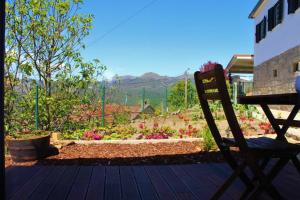 eine Holzterrasse mit einer Bank und einem Garten in der Unterkunft Lagoon Tiny House in Arcos de Valdevez