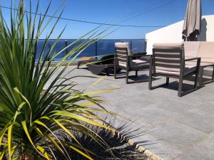 two chairs and a table on a patio at Calheta Ocean View Apartment 2 in Estreito da Calheta