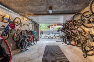 un garaje con un montón de bicicletas colgando en la pared en Gasthof Alpensport - Joker Card included, en Saalbach Hinterglemm