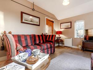 a living room with a couch and a table at Manor Cottage Bungalow in Wetheringsett
