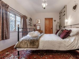 um quarto com uma cama grande e uma janela em Manor Cottage Bungalow em Wetheringsett