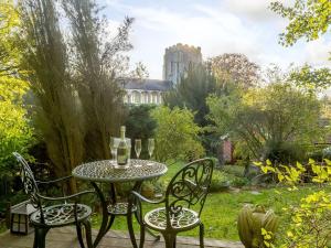 een tafel en stoelen op een terras met een tuin bij Manor Cottage Bungalow in Wetheringsett