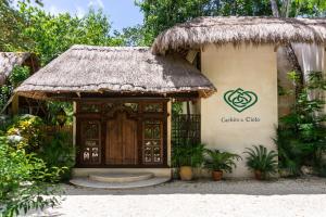 Cachito de Cielo Luxury Jungle Lodge في تولوم: مبنى صغير فيه باب وسقف عشبي