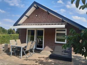 een tafel en stoelen voor een bakstenen huis bij De Steegberg Holiday Home in Sevenum