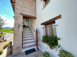 a white house with stairs and a window at Agriturismo Le Castellare in Montemonaco