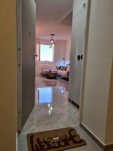 einen Flur, der zu einem Wohnzimmer mit einem Sofa führt in der Unterkunft Apartment "50 Shades" with balcony and free parking in the garage in Zadar
