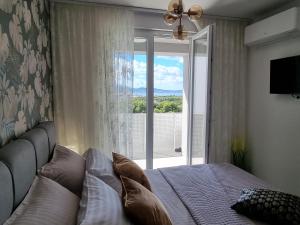 扎达尔Superb Apartment "50Shades" with balcony and free parking in the garage的一间带床和大窗户的卧室