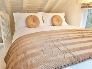 a large bed with two pillows on top of it at The Hazeling Hideaway in Stroud