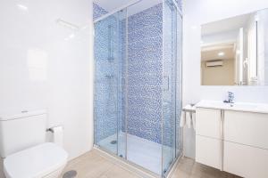 uma casa de banho com uma cabina de duche em vidro, um WC e um lavatório. em Apartamentos La Rosita Old Town em Benidorm