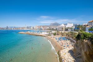 a beach in a city with people in the water at Apartamentos La Rosita Old Town in Benidorm