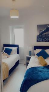 um quarto com 2 camas em azul e branco em Plaza lodge em Gillingham