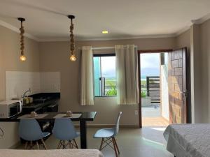 een keuken en eetkamer met een tafel en stoelen bij Éolos Loft's - Cabo Frio in Cabo Frio