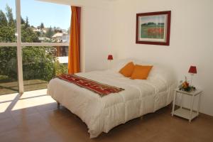 1 dormitorio con cama y ventana grande en Departamento Espejo en San Carlos de Bariloche
