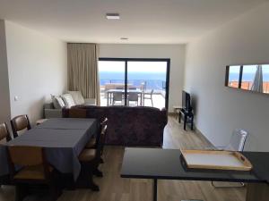 ein Wohnzimmer mit Sofa und Tisch in der Unterkunft Calheta Ocean View Family Apartment - Air Condition in Estreito da Calheta