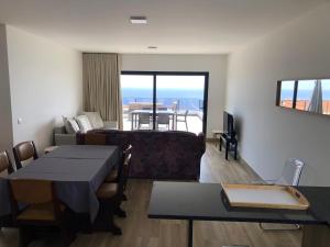 - un salon avec un canapé et une table dans l'établissement Calheta Ocean View Family Apartment, à Estreito da Calheta
