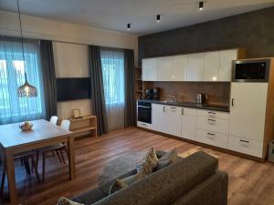 cocina y sala de estar con sofá y mesa en Appartements König, en Merano