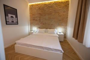 a bedroom with a bed and a brick wall at Carol Residence in Timişoara