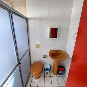 a small bathroom with a toilet and a sink at Residencial Bem Estar in Bombinhas