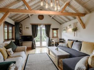 a living room with couches and a table at Brook Farm Annex in Tenterden