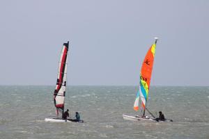 Tres personas están haciendo windsurf en el océano en el agua en Rozéliande, en Roz-sur-Couesnon