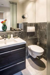 een badkamer met een toilet, een wastafel en een spiegel bij KeizersgrachtSuite471 in Amsterdam