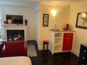 a living room with a red cabinet and a fireplace at The Platinum Pebble Boutique Inn - Adults Only Property in Harwich Port