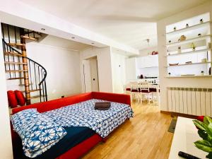 a living room with a red couch and a dining room at Casetta Nica in Torvaianica