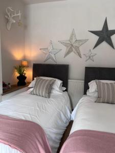 duas camas num quarto com estrelas na parede em CWTCH COTTAGE Llantrisant 2 bed home - sleeps 4 em Llantrisant
