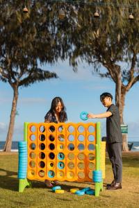 a man and a woman playing with an outdoor game at Kauai Shores Hotel in Kapaa