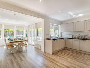 a kitchen with white cabinets and a table and a dining room at Headland View in Banff