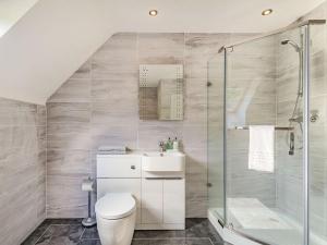 a bathroom with a toilet and a glass shower at Headland View in Banff
